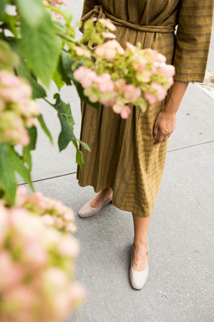 Top view picture of pink flowers with a model in the Epic Heel in background. 