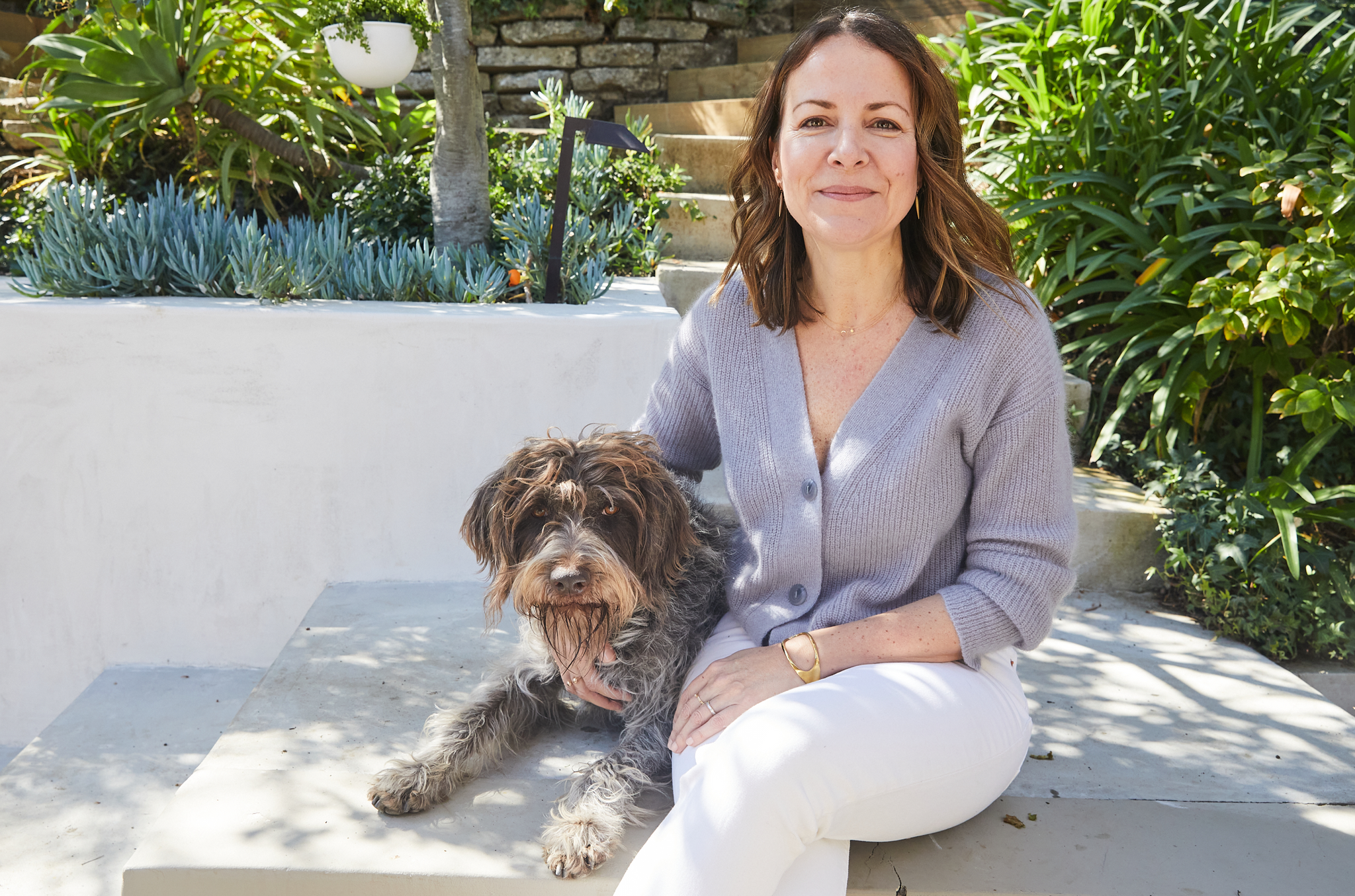 Mariapaz Fernandez sitting outdoors with her dog.