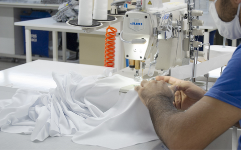 factory worker sewing cotton together