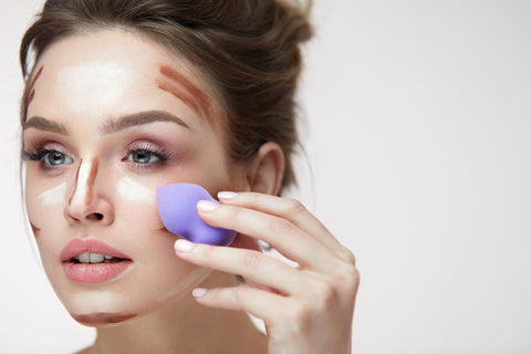 girl blending makeup with a beauty sponge raw beauty minerals