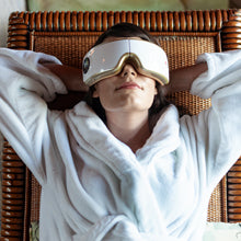 Woman relaxes wearing eye and temple massager