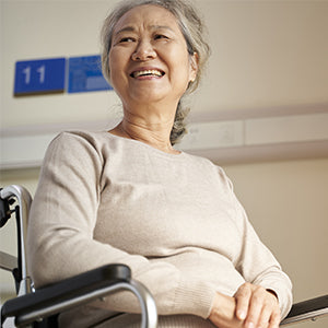 BodyMed Shower Seat - Woman smiling while sitting in wheelchair
