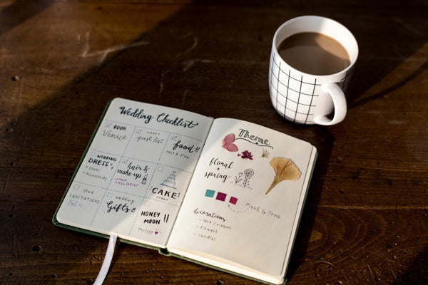 closeup of wedding checklist for groom on notebook on wooden table