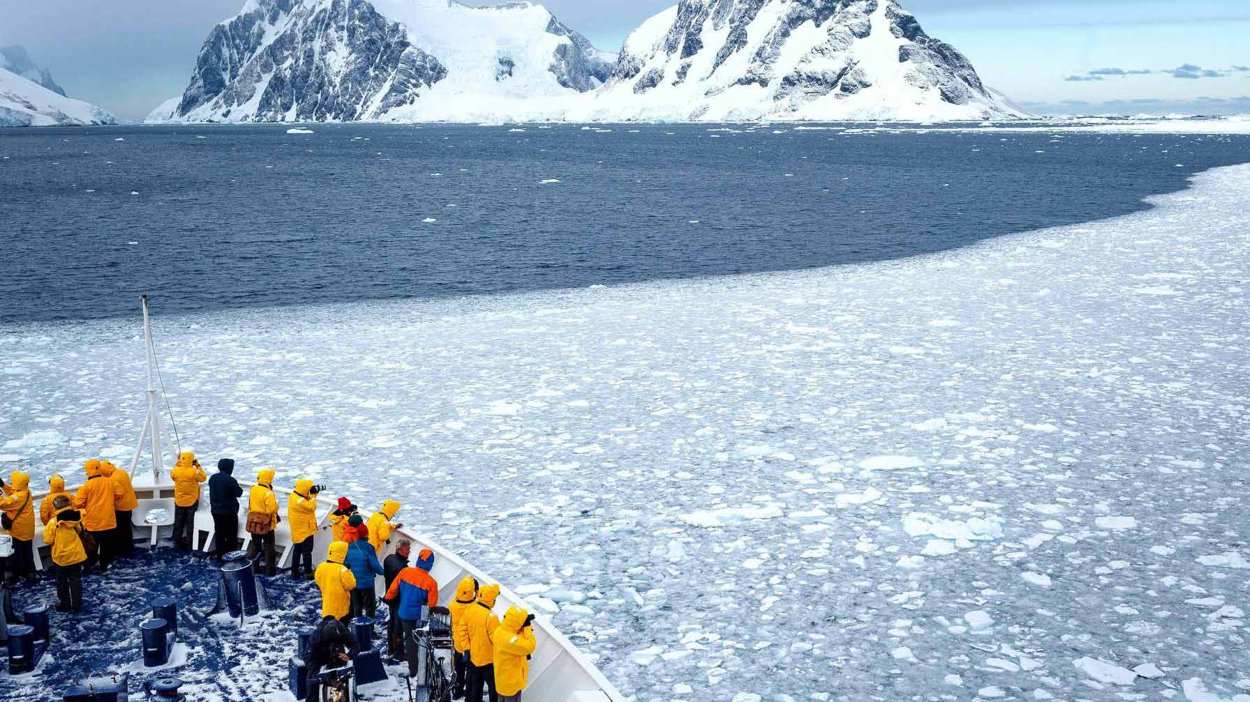View of Icebergs in Antarctica with people watching the view from cruise ship.