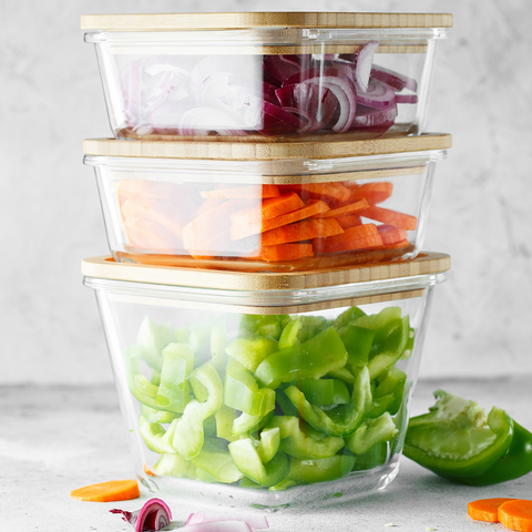 Stacked glass containers with chopped vegetables in it