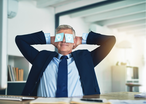 A corporate man posing his arms up and have some sticky notes sticked on his eyes