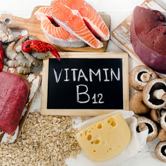 Flat lay of blackboard with written text Vitamin B12 and different food such as fish, cheese, oats, and mushroom