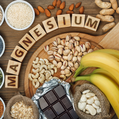 Flat lay of food with small wooden squares forming the word Magnesium surrounded with different food