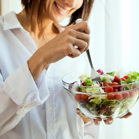 Girl holding a bowl of salad and a fork