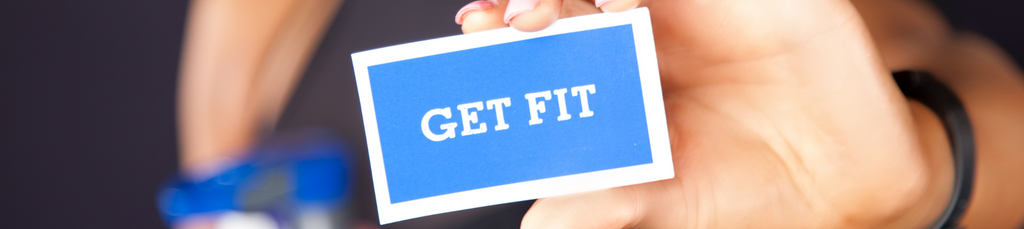A hand holding a small card with a text "Get Fit"