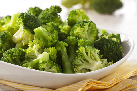 a bowl of broccoli on a yellow napkin