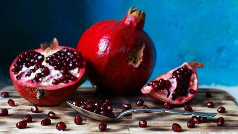 a pomegranate with a spoon and seeds