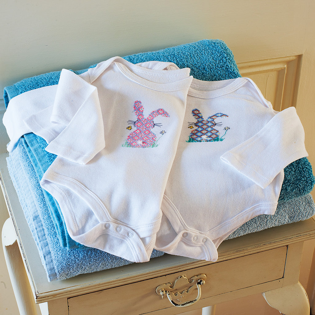 Cross-stitch bunny baby-grows in blue and pink