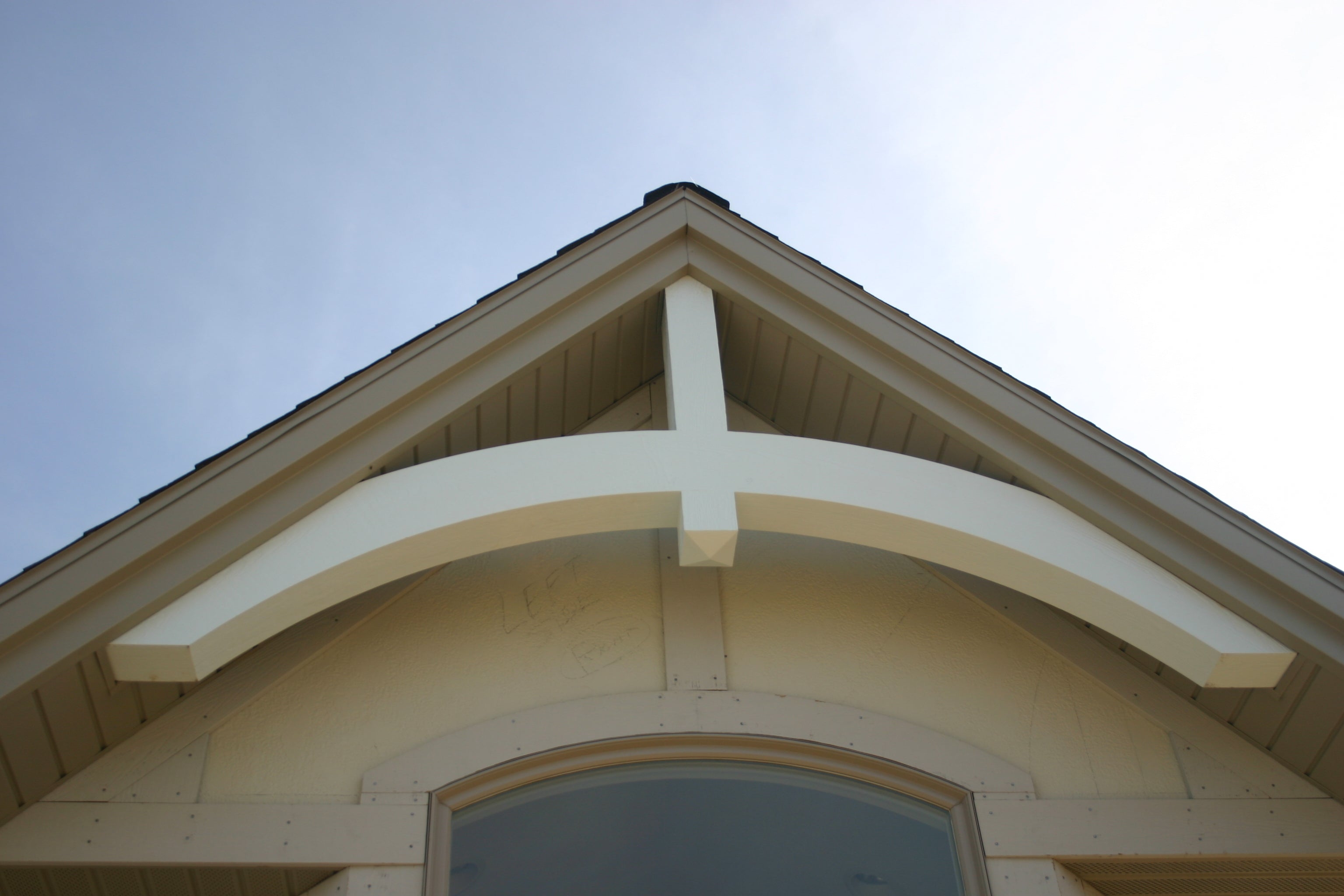 A close-up image of a white gable decoration installed on a home.