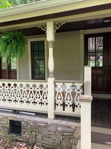 This home’s porch has PVC trim used in the deck’s design. There is a hanging plant on the porch.