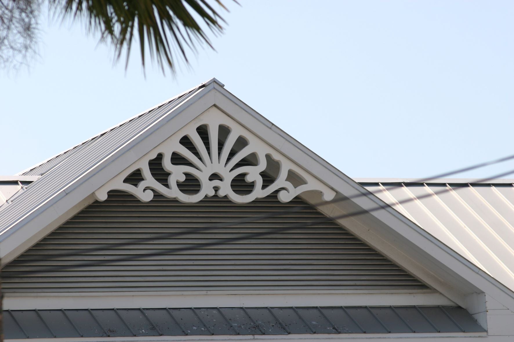 This is a close-up image of white gingerbread gable trim with a simplistic design.