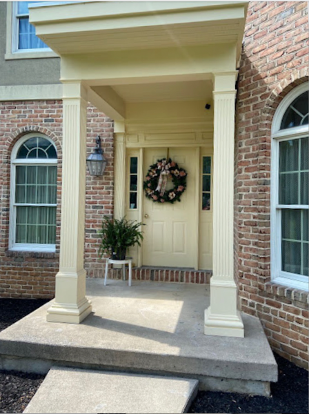 This brick home has an entryway with custom column wraps.