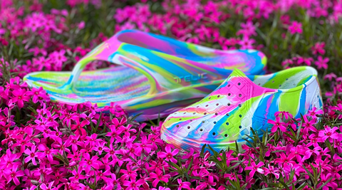 Award-winning limited edition multi-colored sandals floating in a bed of spring flowers