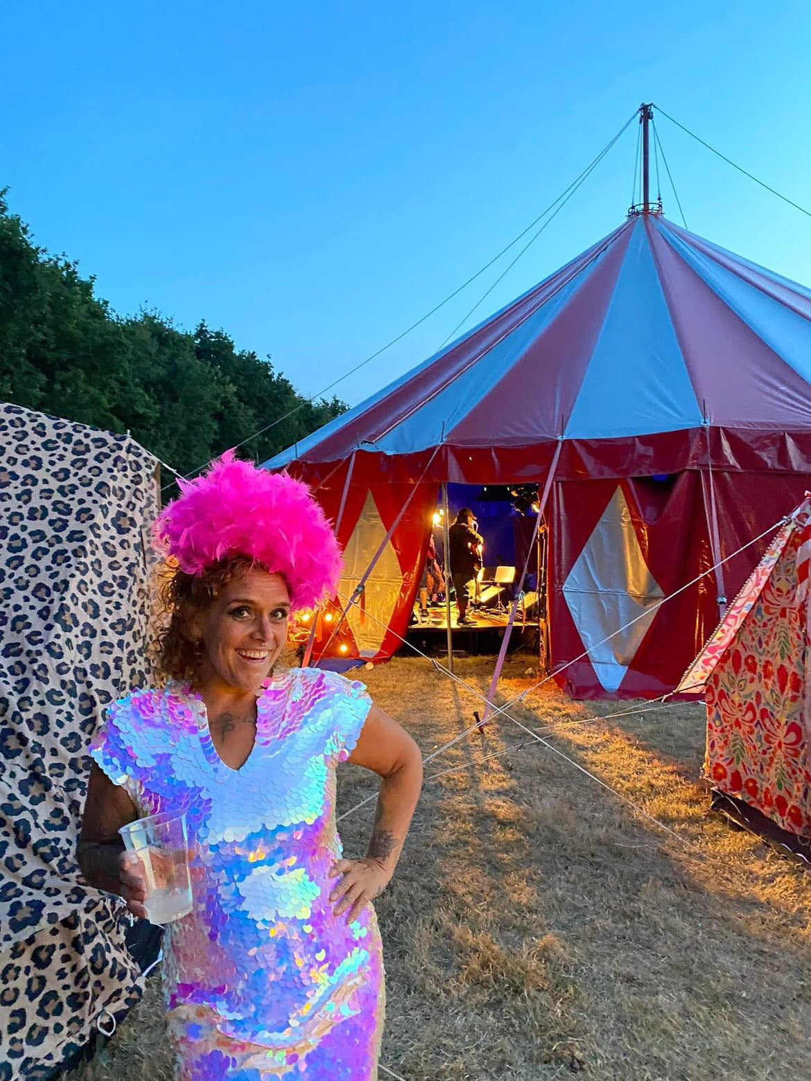 Woman smiling at sundown at a festival with pink headadress wearing Rosa Bloom Sequin Dress in Opal white