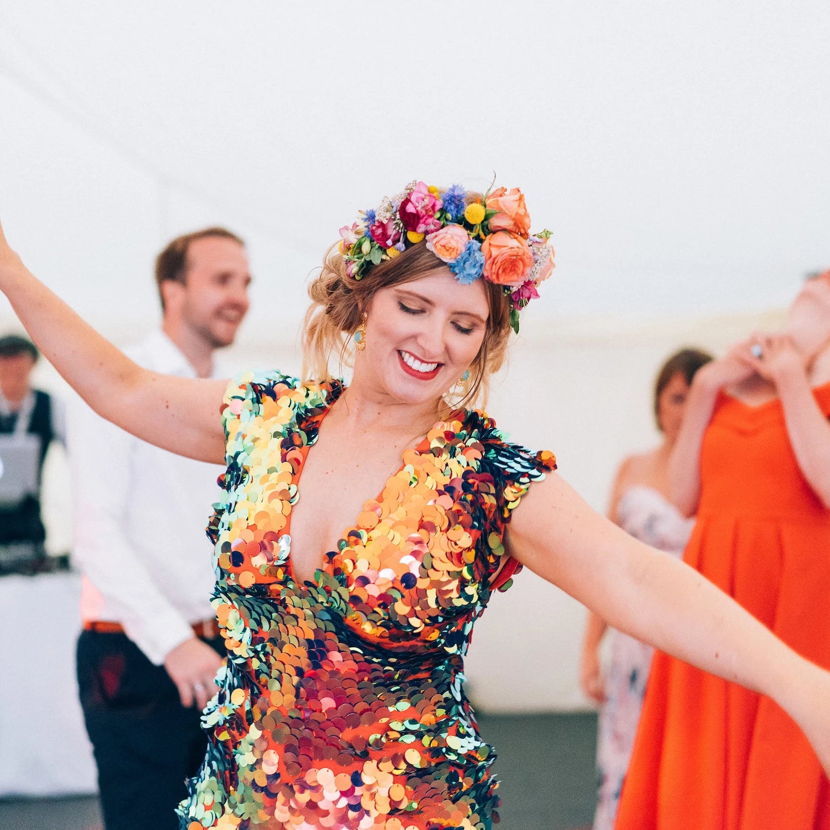 A bride wears a colourful headdress and full sequin jumpsuit