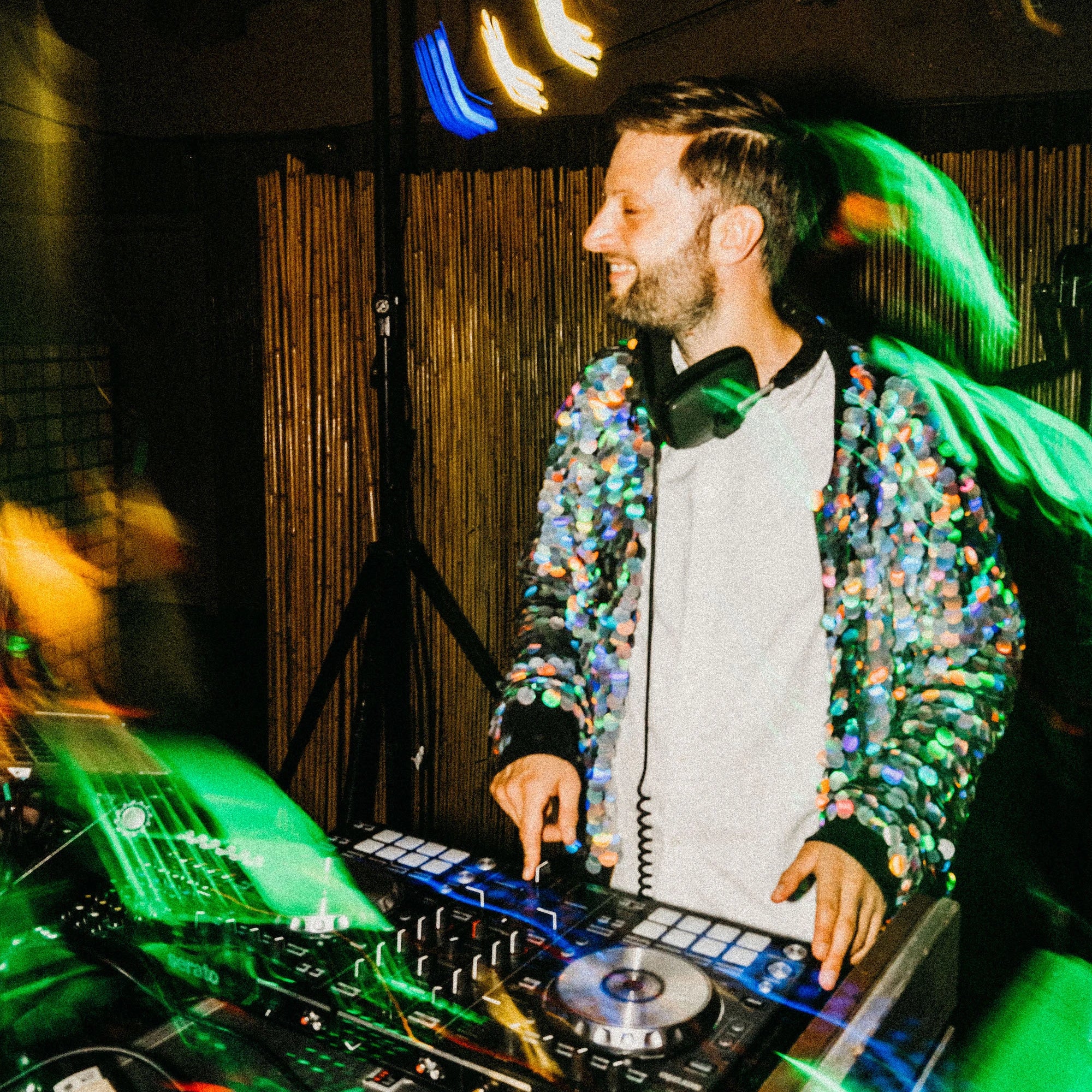 A wedding DJ performs in a sequin bomber jacket