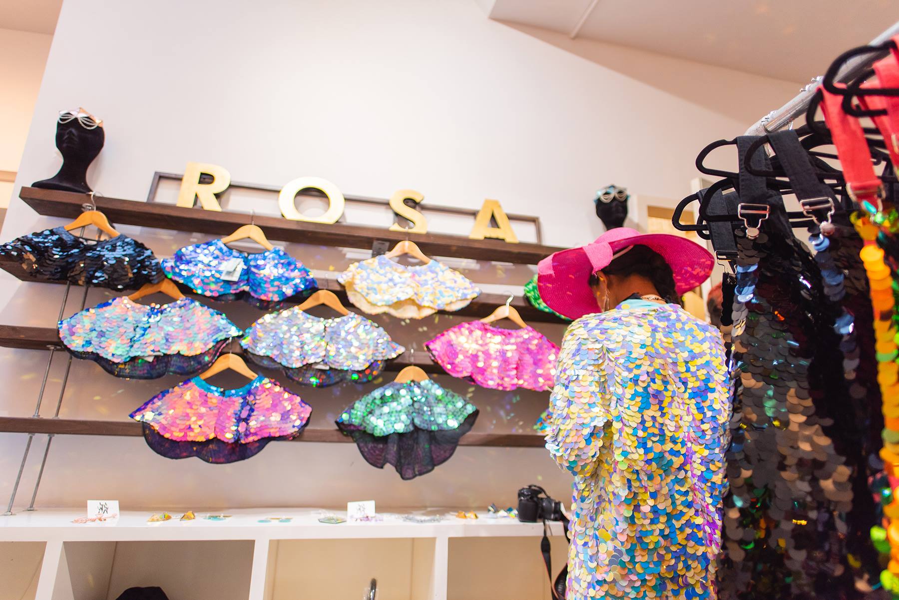 A customer in a pink hat browses a sequin clothing store