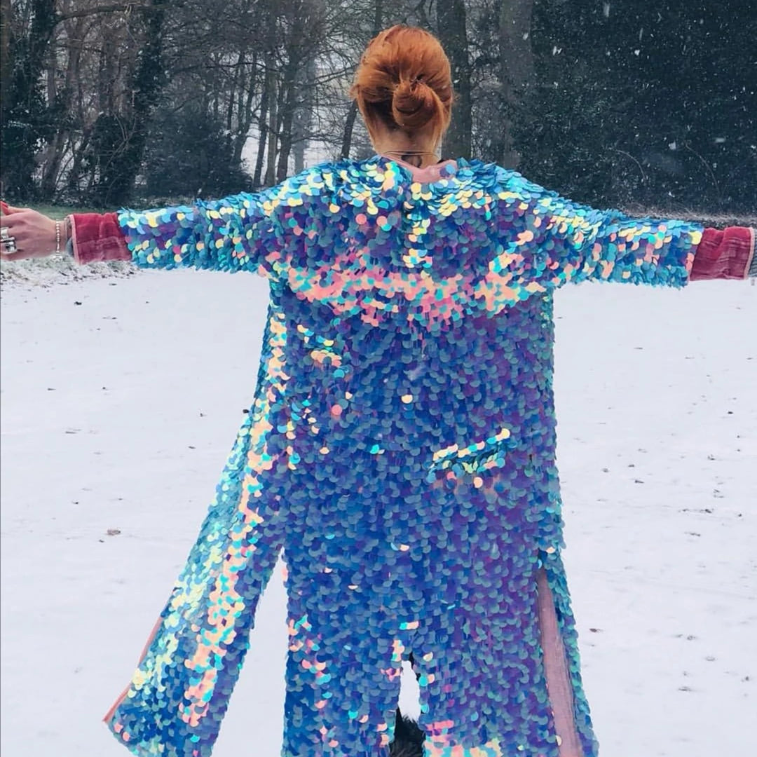 A woman wears a blue sequin kimono in the snow