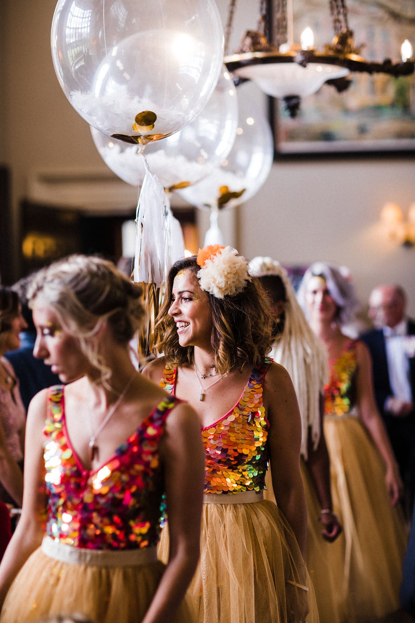 Bridesmaids walk down the asile wearing festival style bridesmaid outfits 