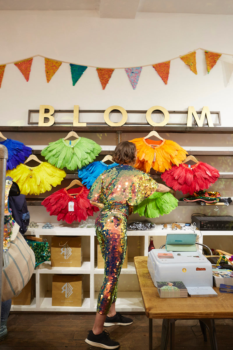 Store owner adjusts a feather cape display