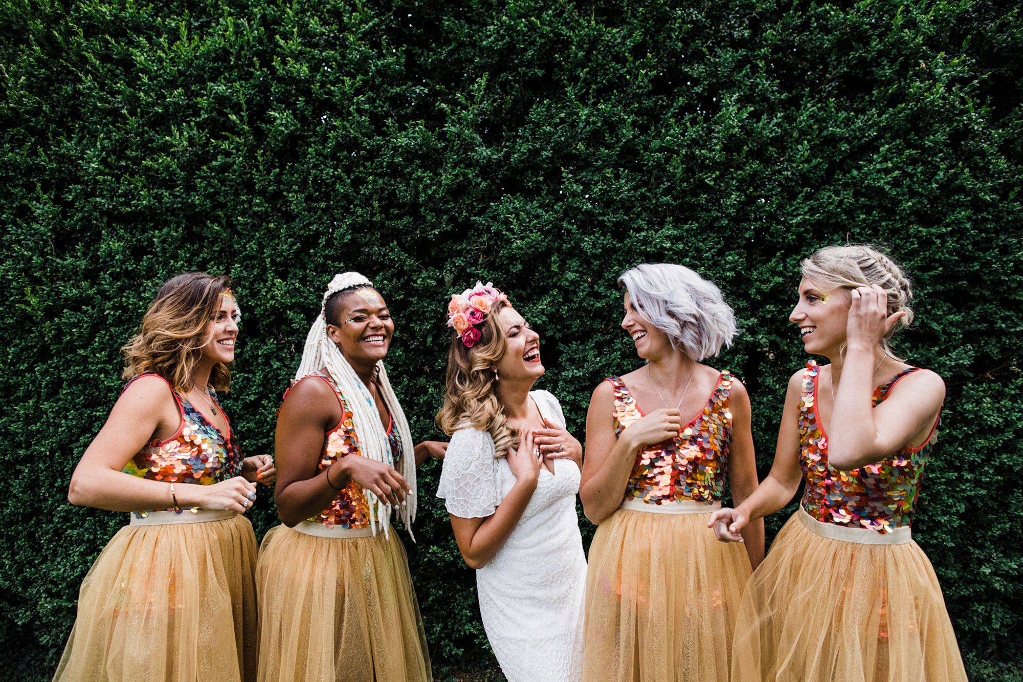 Bride stands with her bridesmaids who all wear sequin clothing