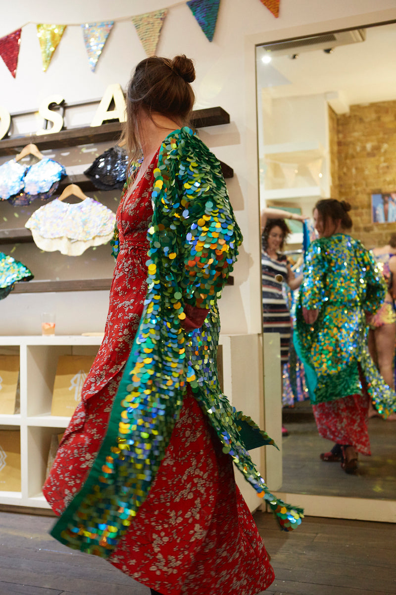 A customer tries on a green sequin kimono at the Rosa Bloom pop-up shop