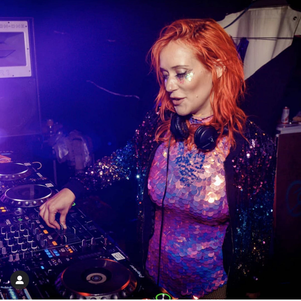 A female DJ performing in a pink sequin leotard