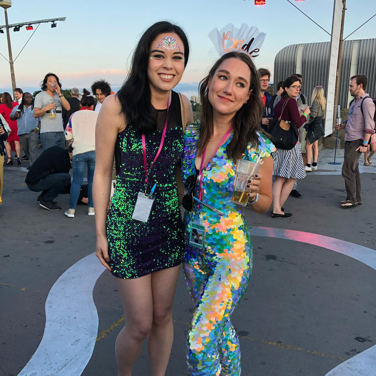 A bride wearing a festival style sequin jumpsuit kises her husband on their wedding day while fireworks go off in the background