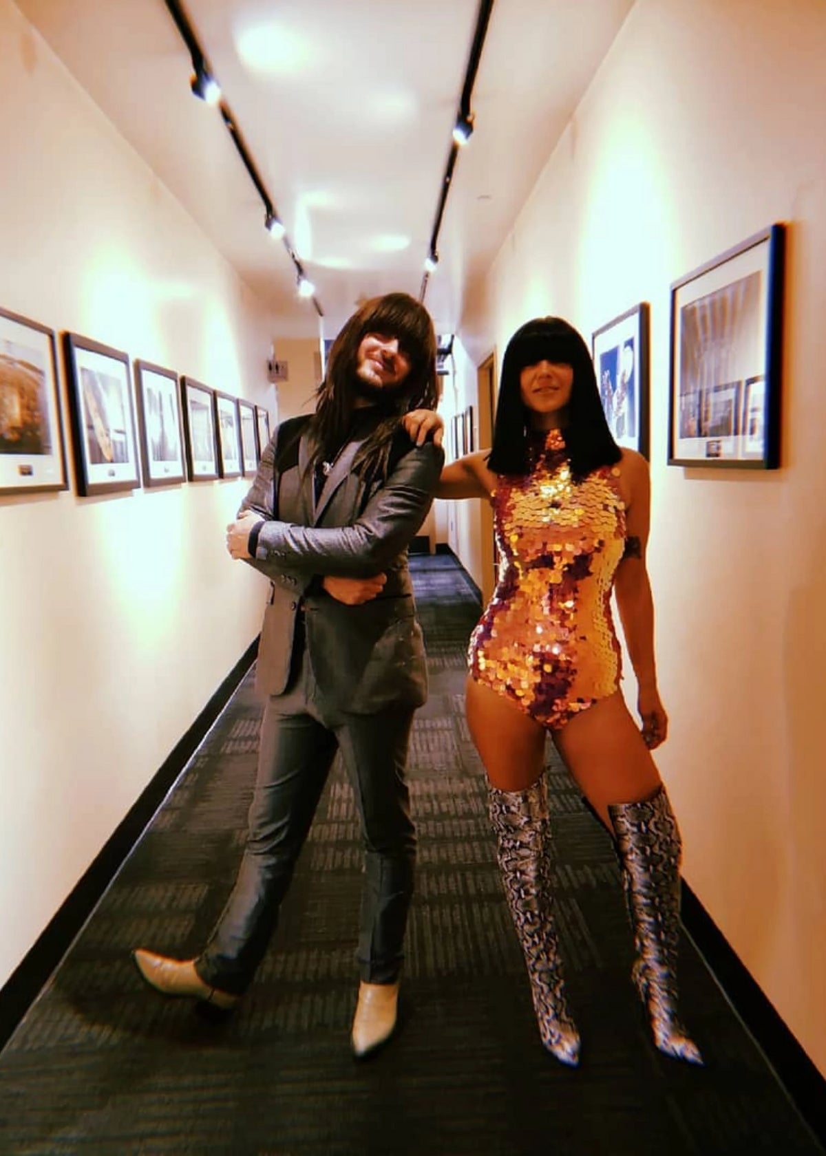 Laura Leezy posing outside of her dressing room wearing knee high silver boots and a Rosa Bloom Sequin Fifi Leotard