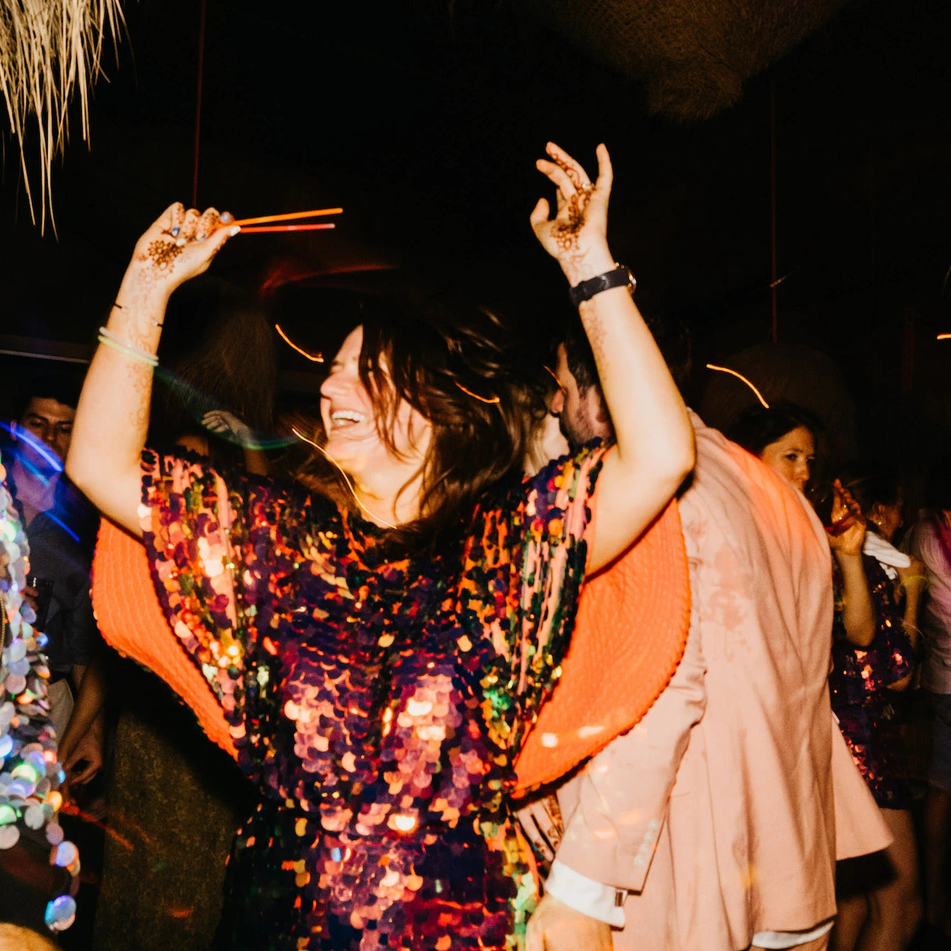 A bride in a red sequin playsuit dances at her wedding