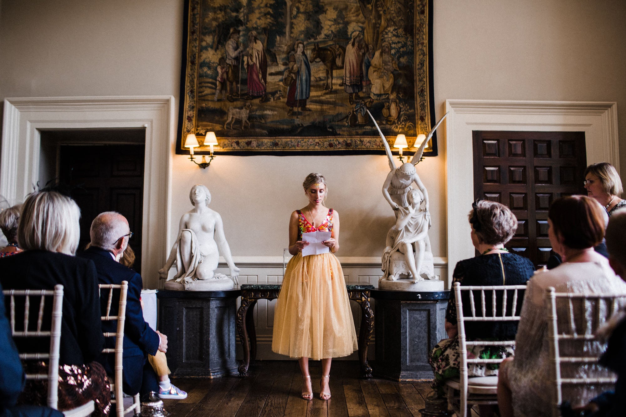A bridesmaid wearing a sequin top gives her reading 