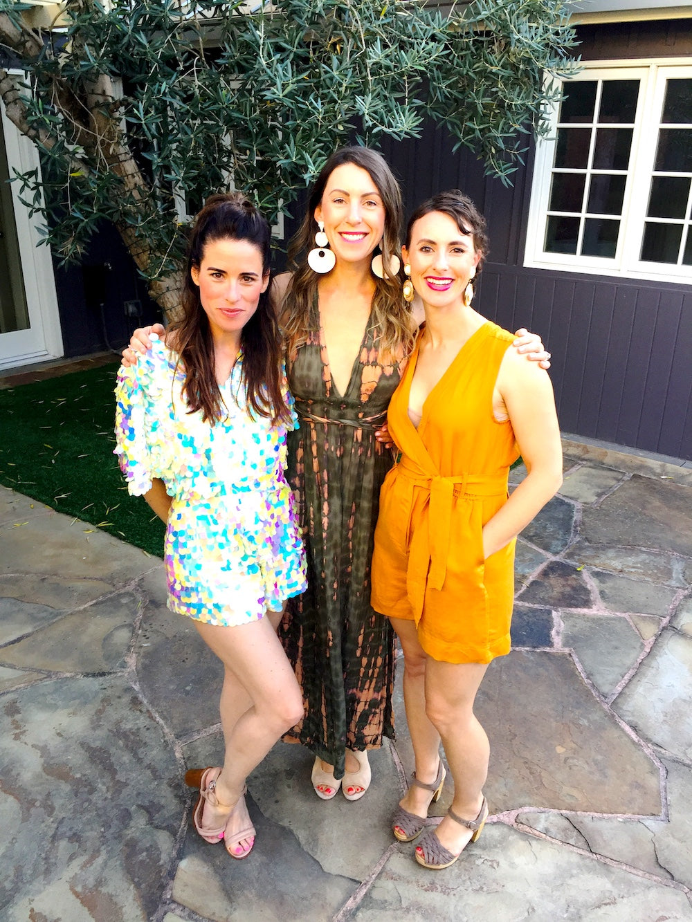 Woman in sequin playsuit poses with friends