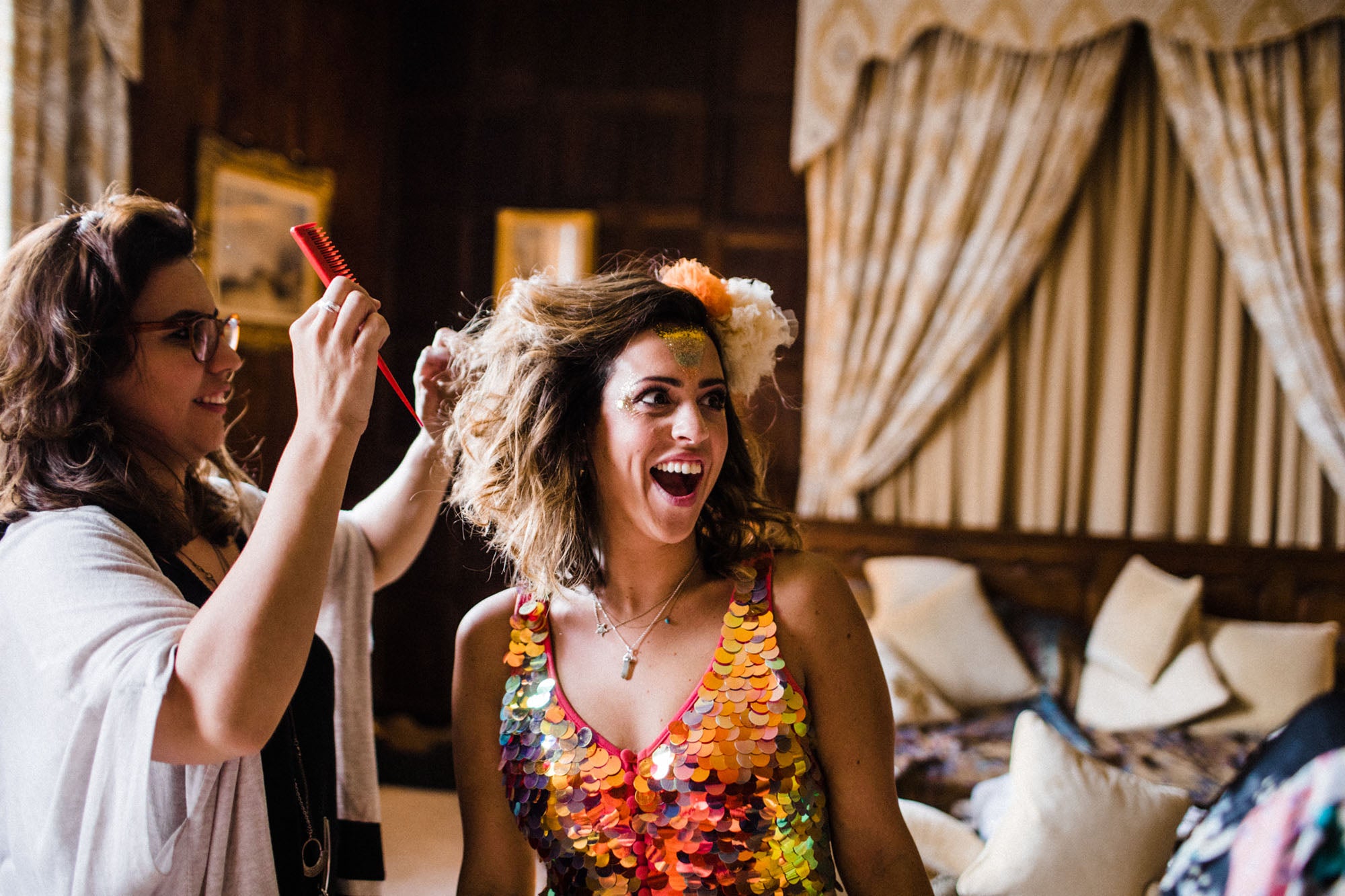 A bridesmaid wearing a sequin top gets her hair done 