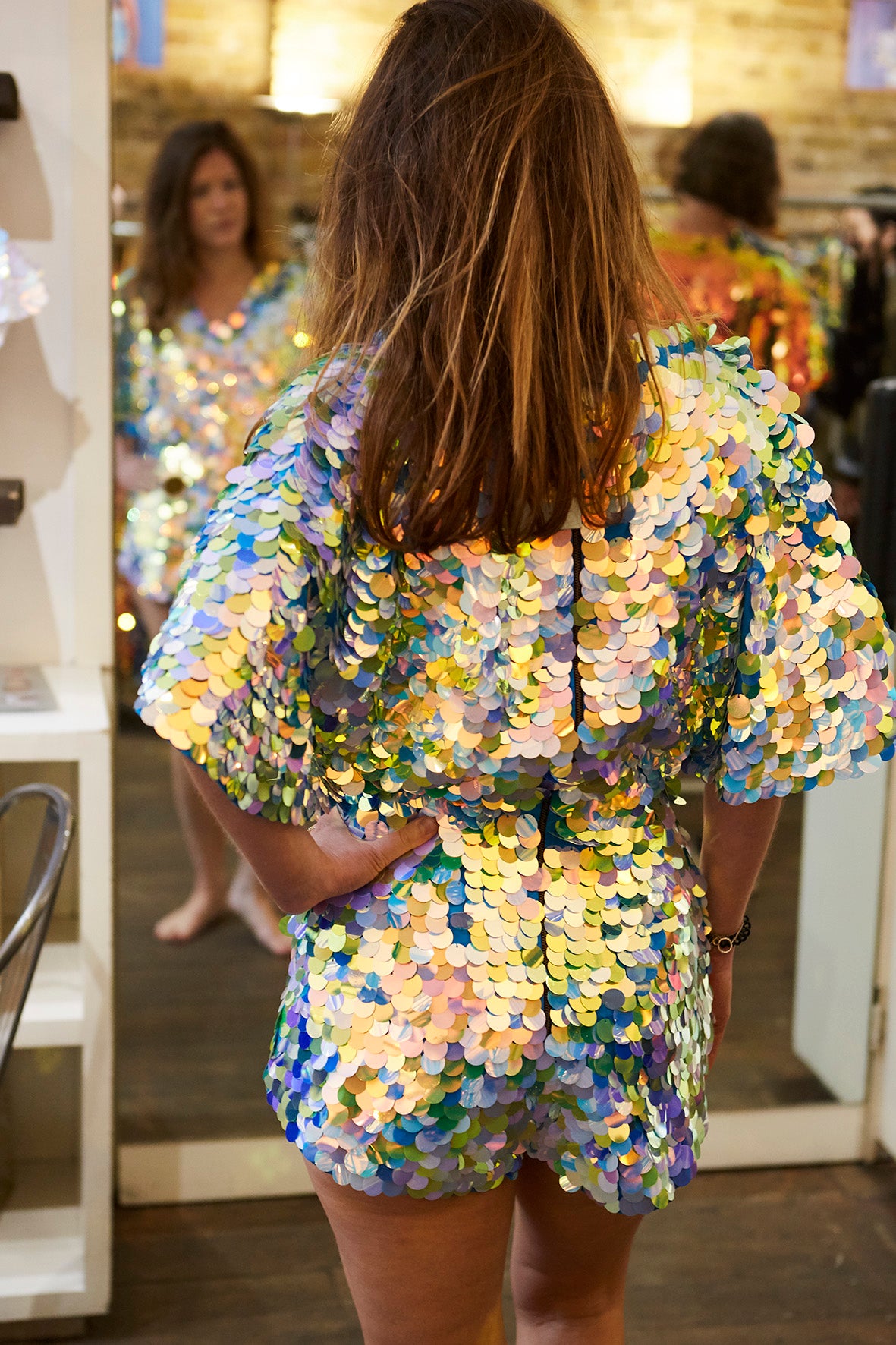 A woman tries on a blue sequin romper