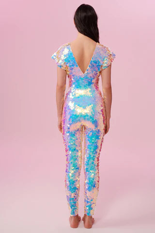 A woman wearing an opal sequin catsuit poses with her back to the camera.