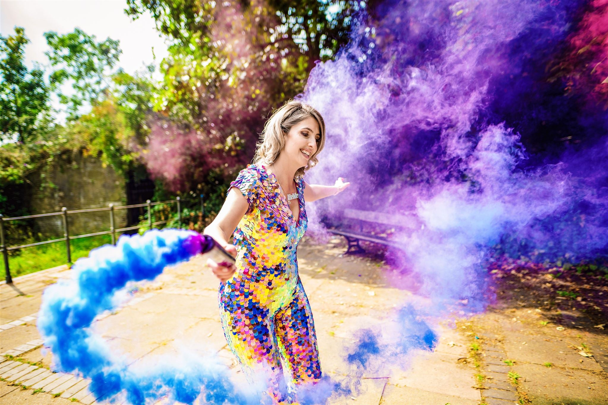 Alt Bride with purple smoke cannons wearing a purple sequin jumpsuit with low neckline