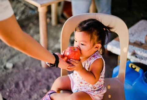 Little girl eating an apple