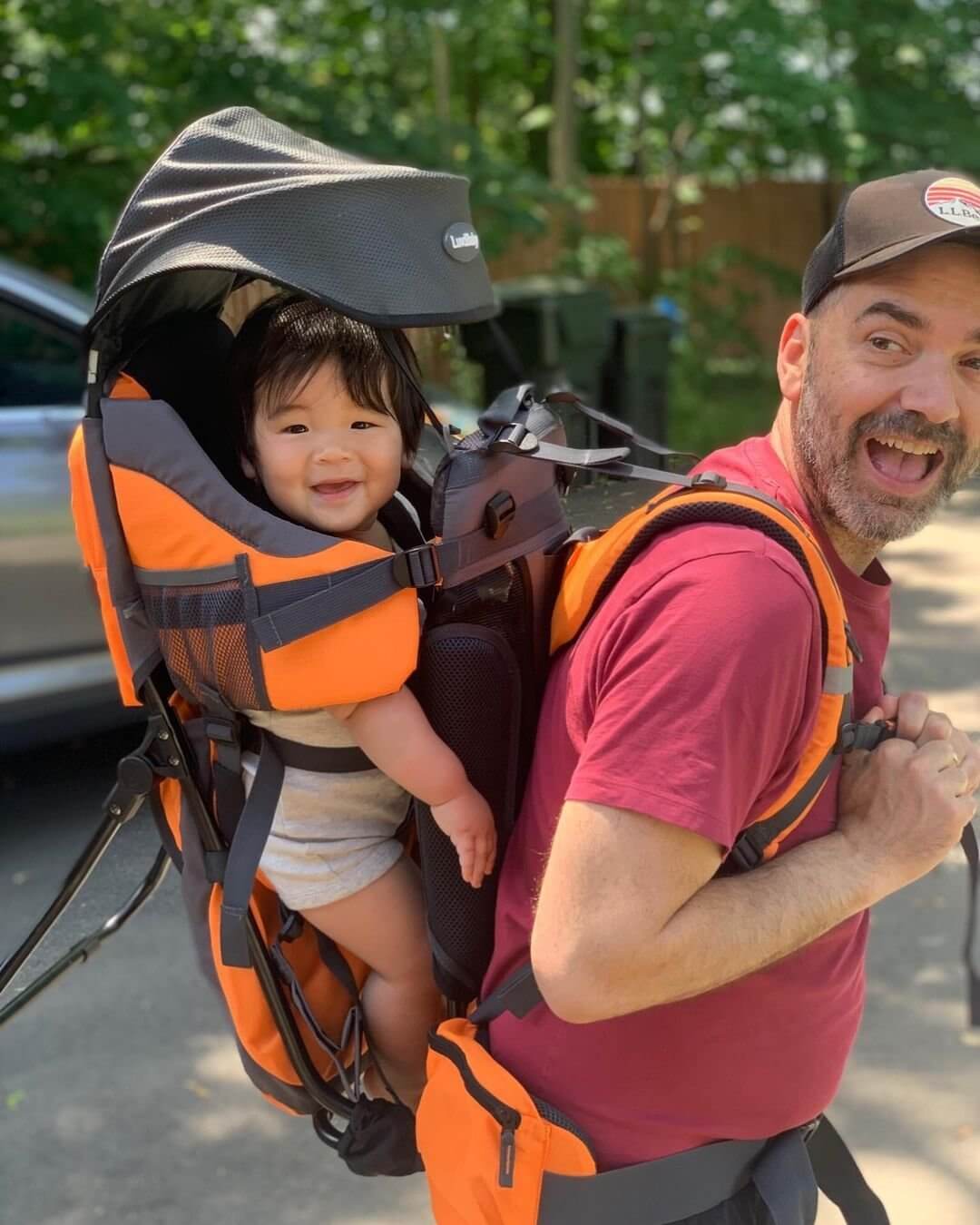 a dad traveling with his kid in a baby carrier