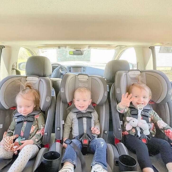 3 kids in a car seat getting ready for a road trip
