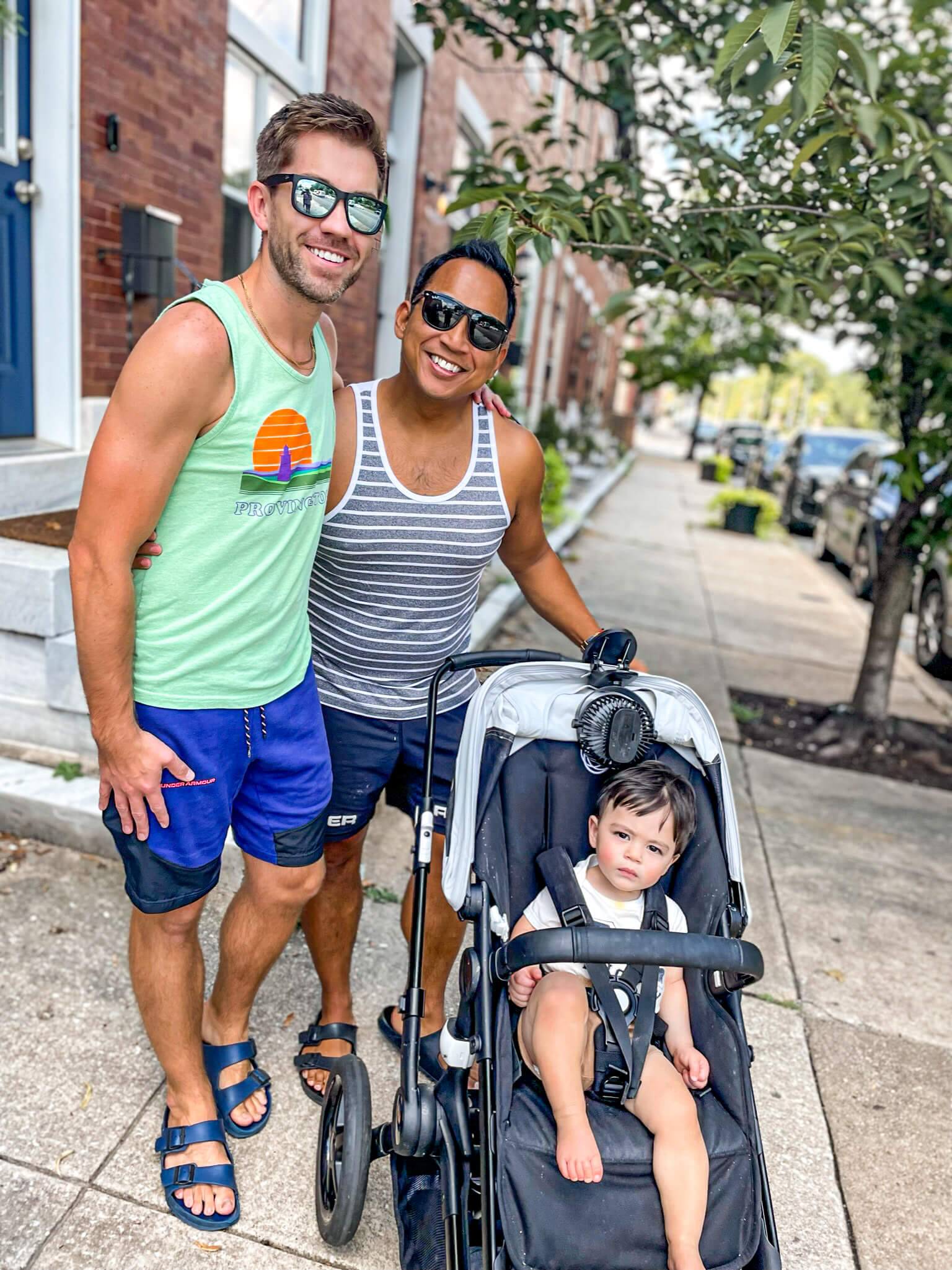 Chad & Michael walking outside with their son in a stroller 