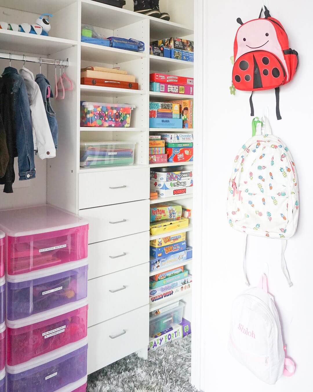 an organized kid's closet with wall shelves and hanging backpacks 