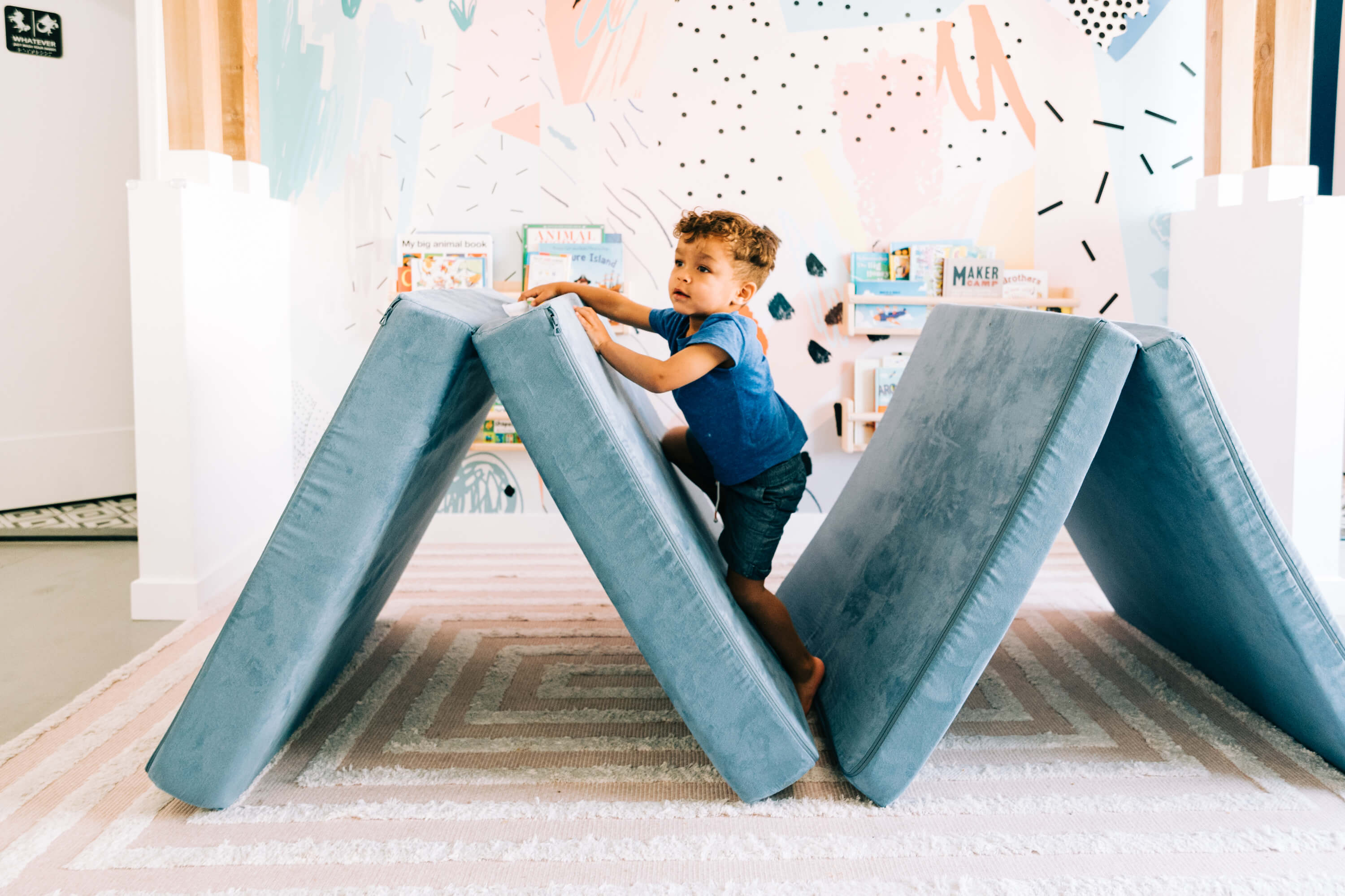 toddler playing on a fort inside 