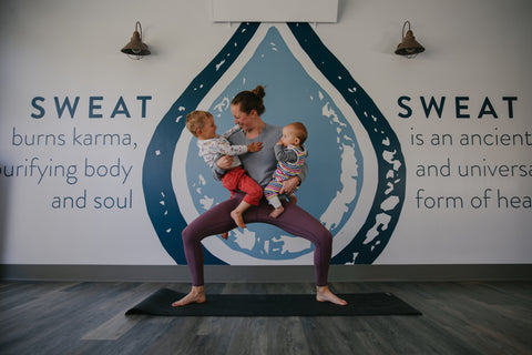 yoga teacher in a pose with her kids
