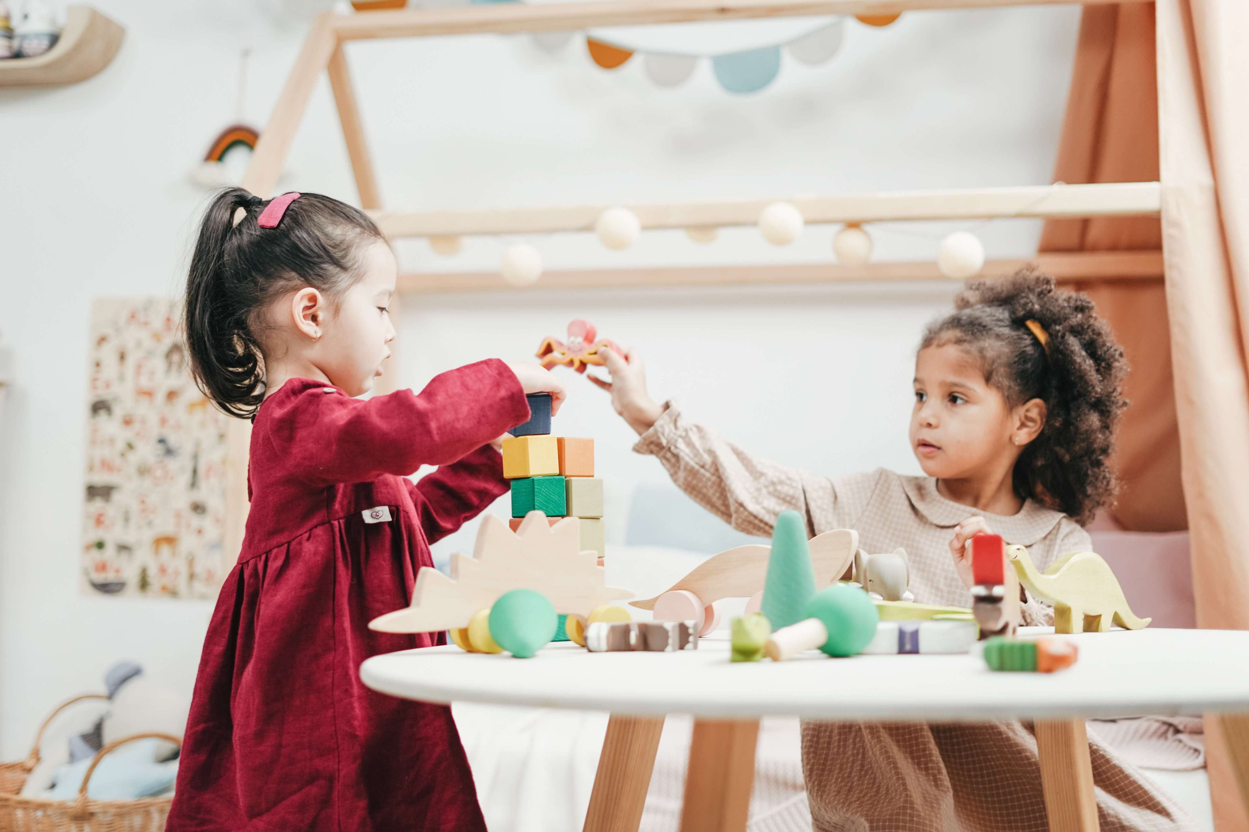 two toddlers playing with wooden Montessori toys 