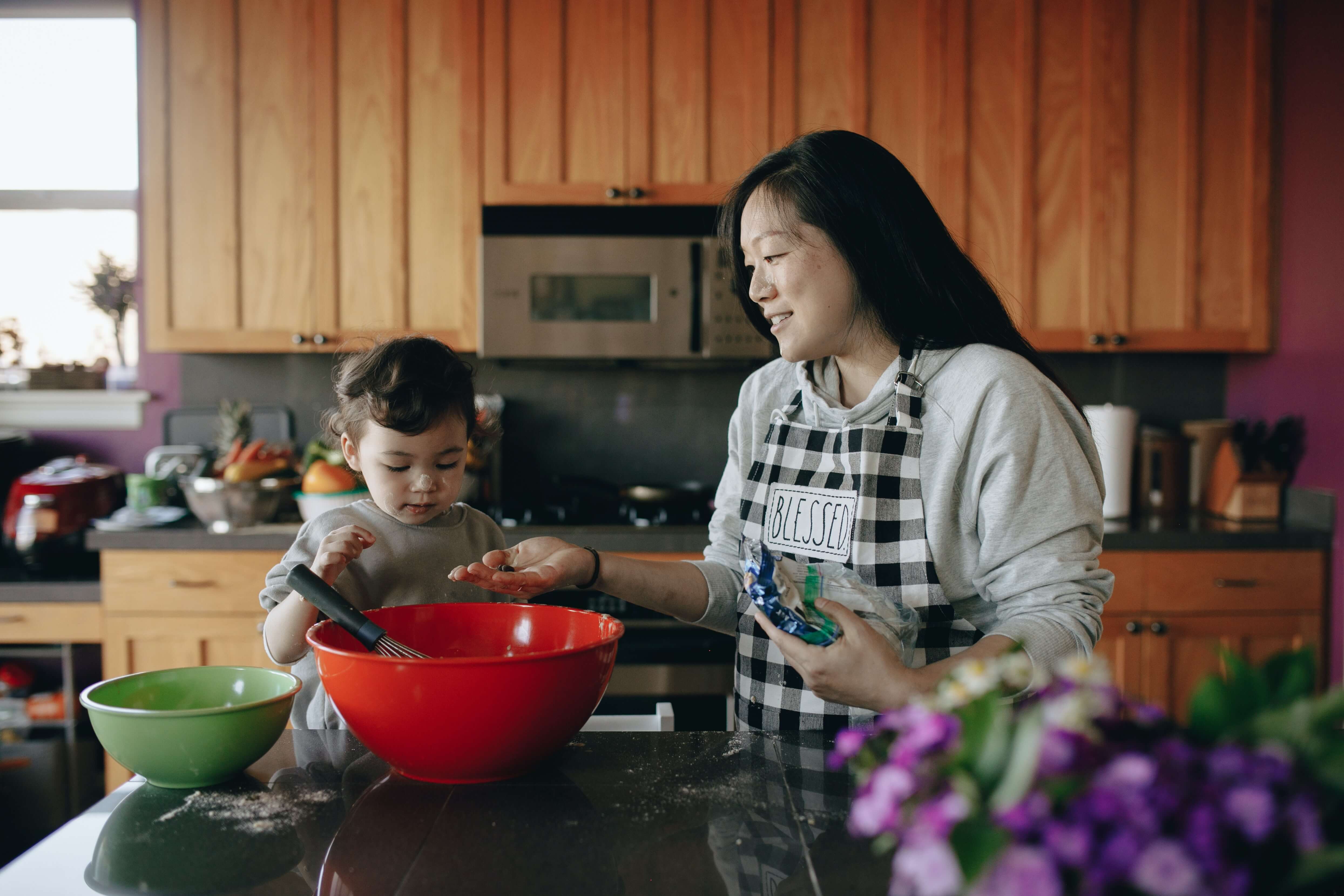 mom and her toddler in the kitchen baking together 